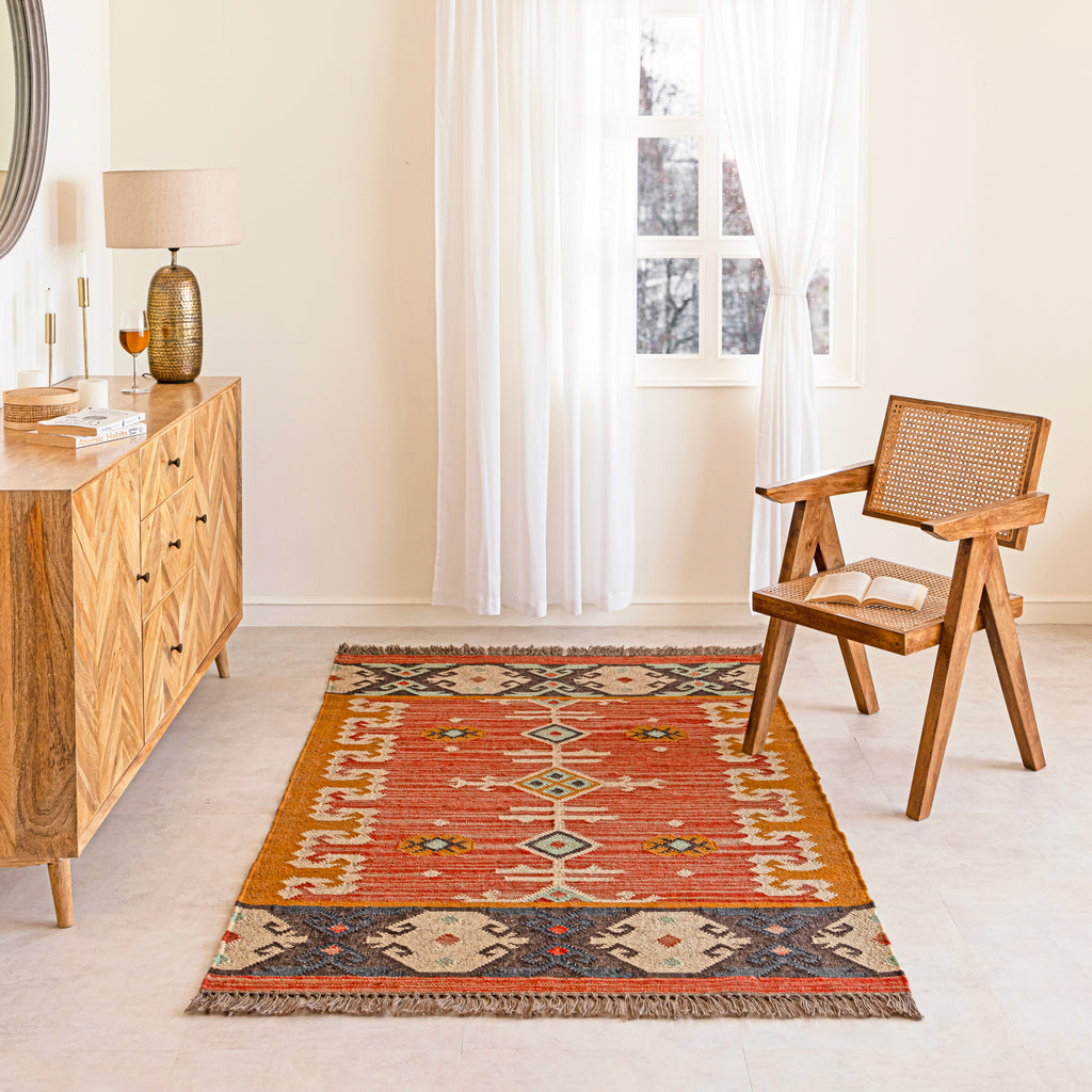 Living room with a patterned jute rug, wooden sideboard, and chair.