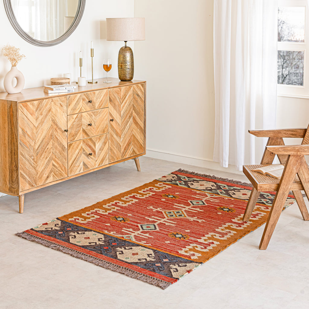 Jute Kilim Rug in living room with wooden sideboard, and wooden chair.