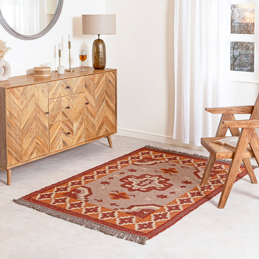Jute kilim rug in living room with wooden sideboard, lamp.