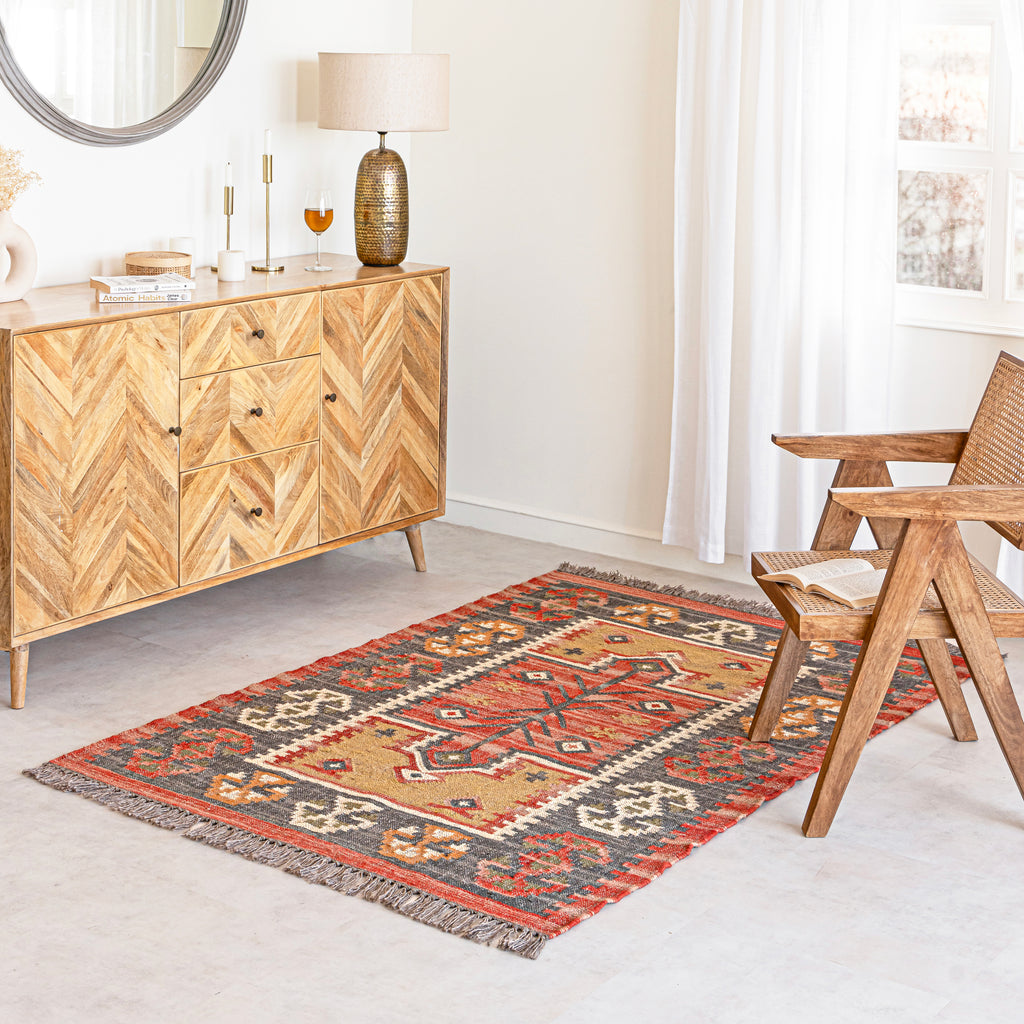 A Wool Jute Rug in living room with wooden sideboard and chair.